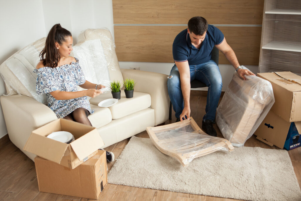 Young couple Moving in new home and unpacking carboard boxes